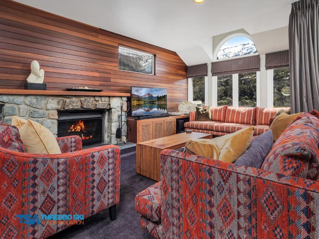 a living room with couches and a fireplace at Aspect 2A in Thredbo