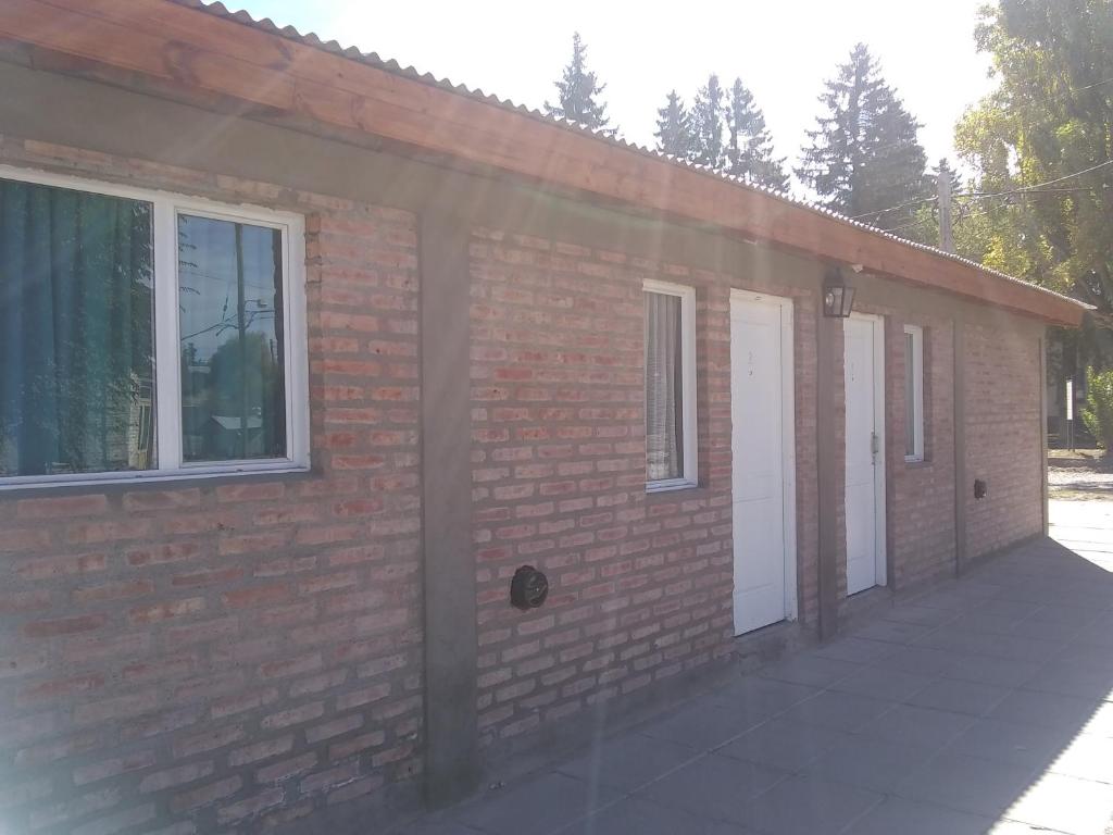 un edificio de ladrillo con dos puertas blancas y una ventana en La Galensa en Trevelin