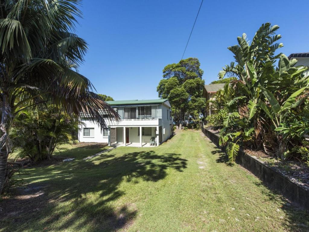 ein Haus inmitten eines Gartens mit Palmen in der Unterkunft Bay Breeze in Iluka