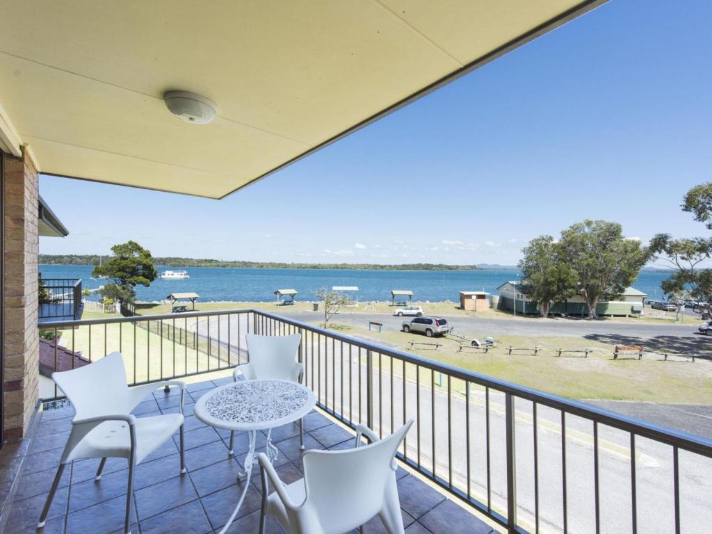 a balcony with a table and chairs and a view of the water at Camawood 11 Iluka NSW in Iluka