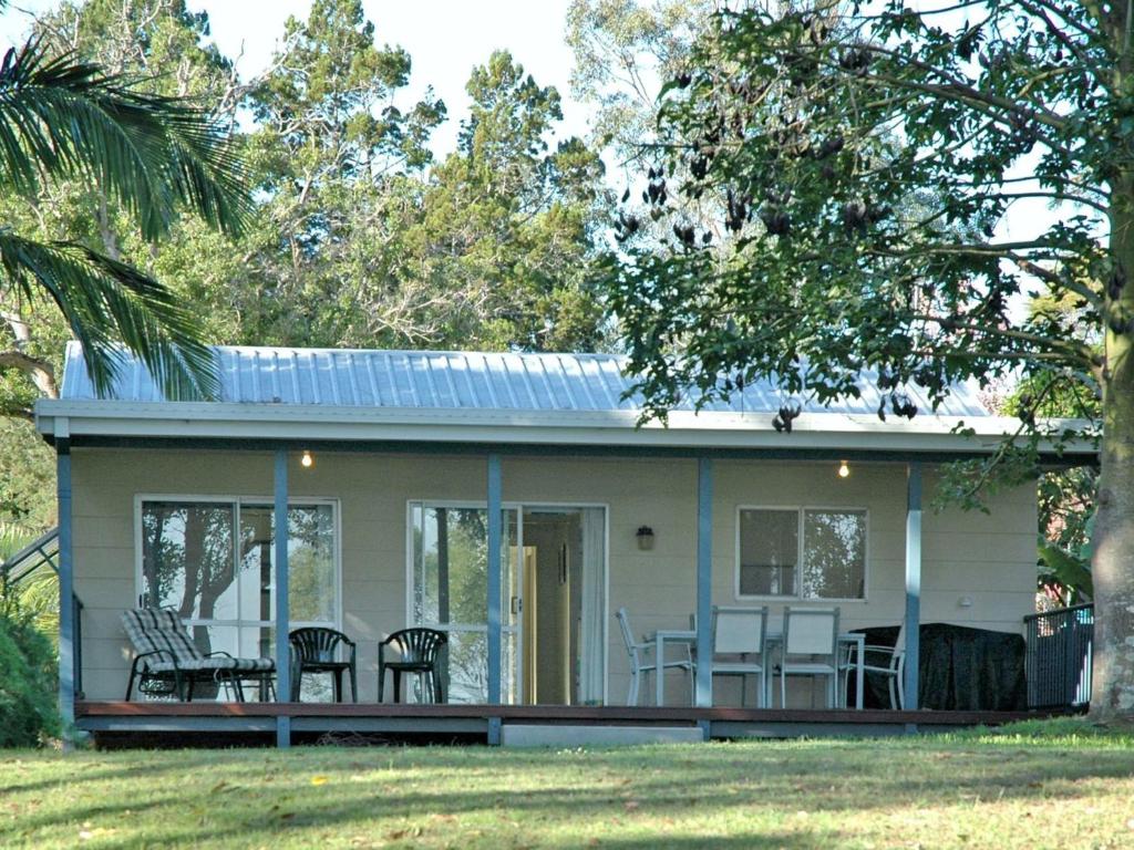 a small white house with chairs and a porch at Bayview at Iluka in Iluka