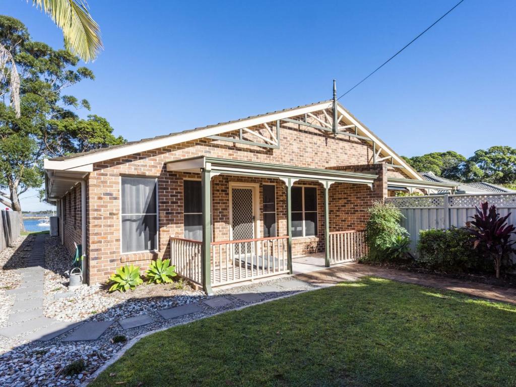 uma casa de tijolos com um alpendre e um quintal em Montrose by the Bay em Iluka