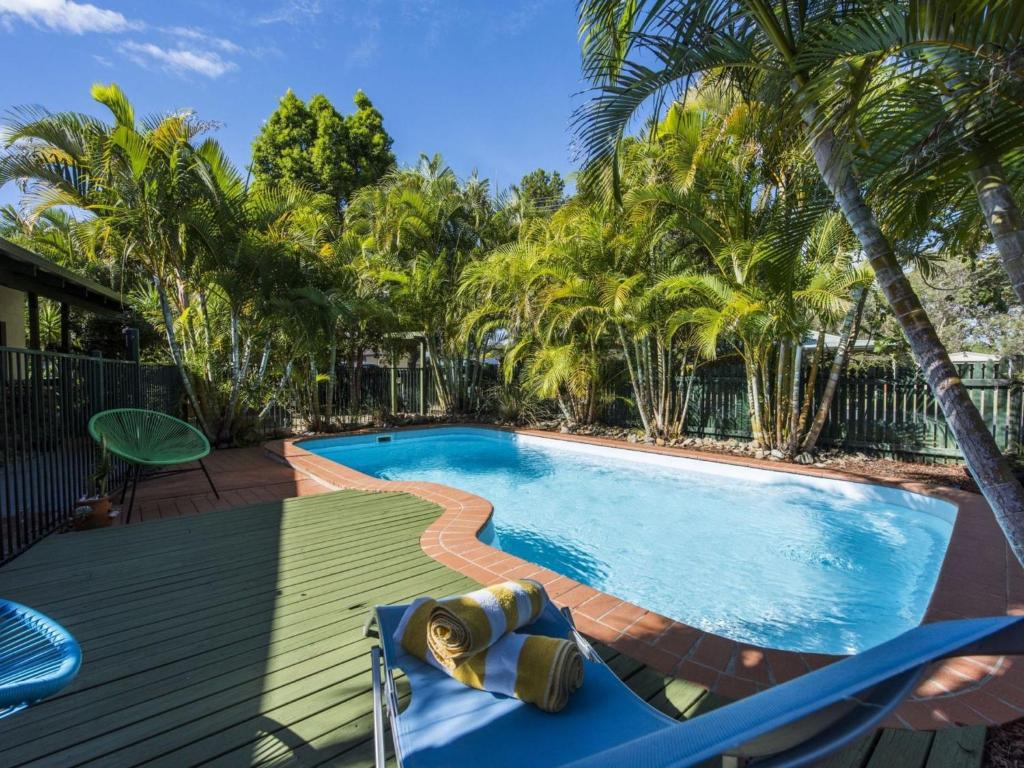 a swimming pool with a deck and a chair next to it at Ohana at Iluka in Iluka
