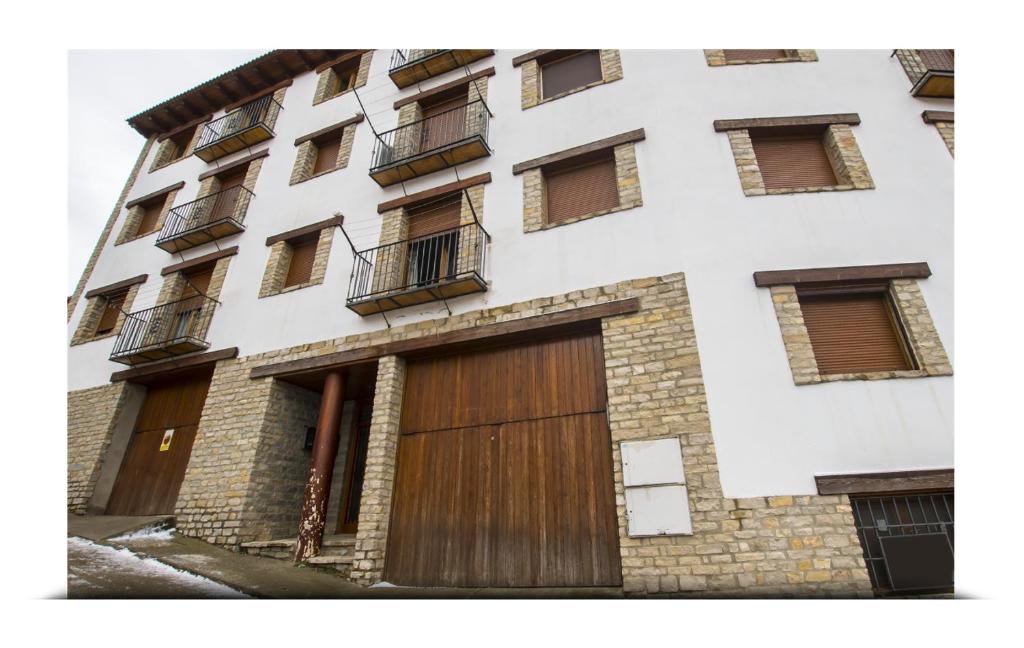 an apartment building with wooden doors and windows at Apartamento Alcala de la selva in Alcalá de la Selva