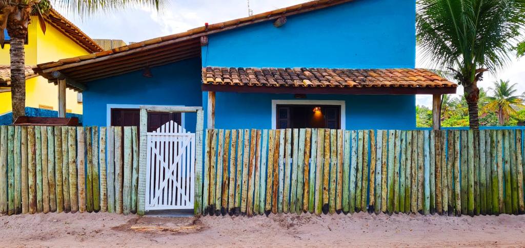 a blue house with a fence in front of it at Casa do Mar Caraíva in Caraíva