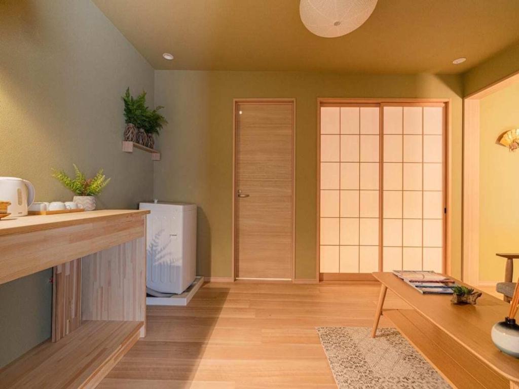 um quarto com uma cozinha com um frigorífico e uma mesa em 桃月庵 -Togetsuan- em Osaka