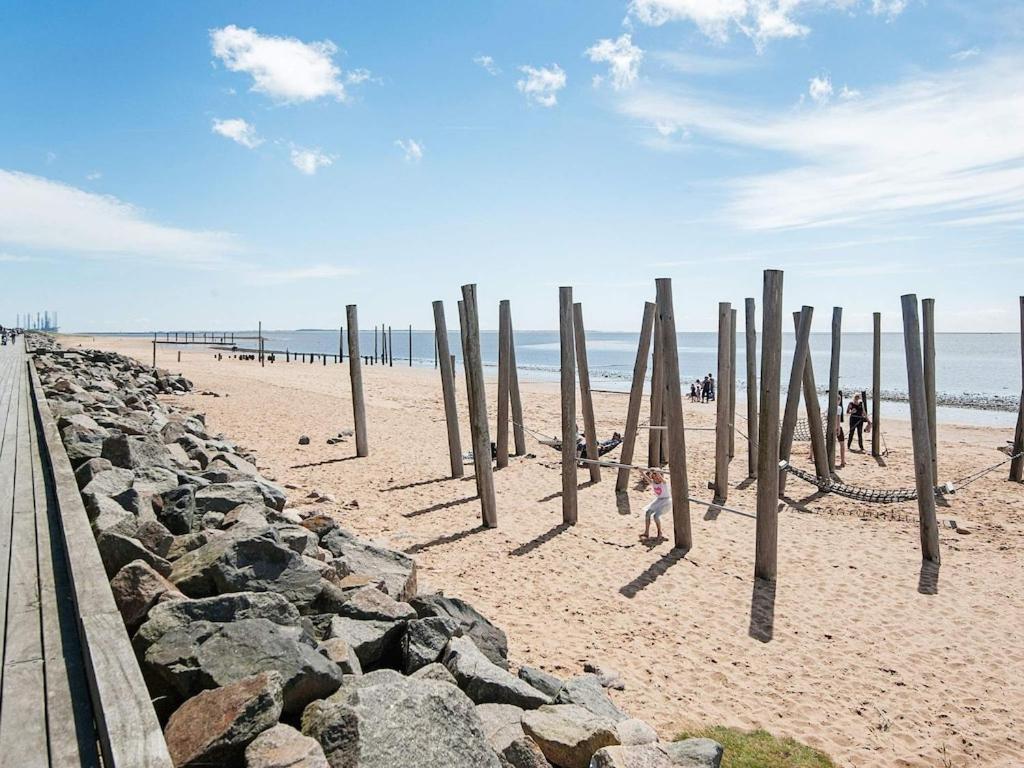 a beach with wooden posts in the sand at 2 person holiday home in Esbjerg V in Esbjerg