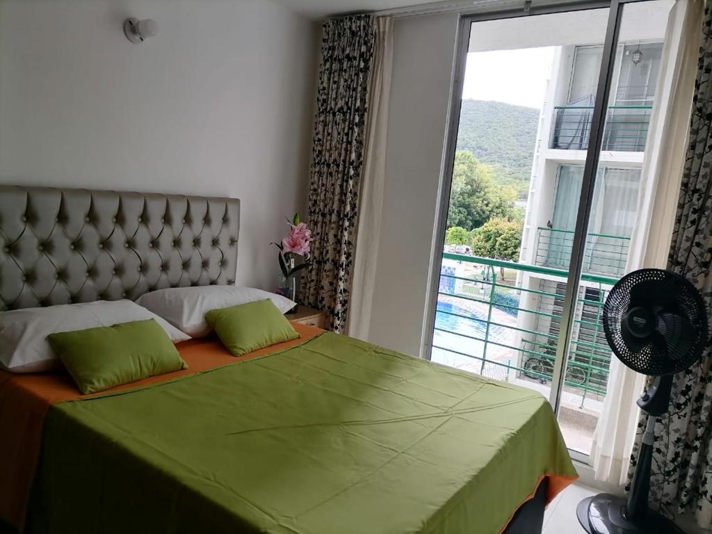 1 dormitorio con cama verde y ventana grande en #Girardot Agua Blanca, en Girardot