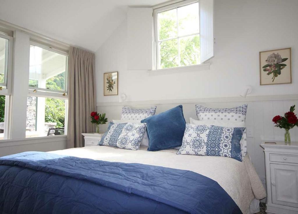 a bedroom with a bed with blue and white pillows at Arrowtown Lodge in Arrowtown