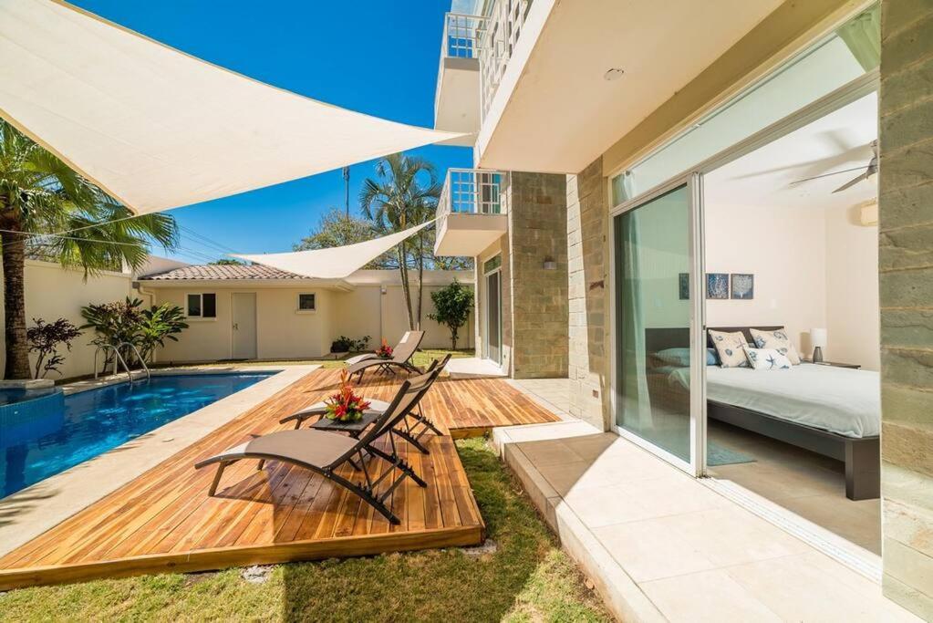 a backyard with a swimming pool and a house at Flamingo Zueños del Mar Condominiums in Playa Flamingo