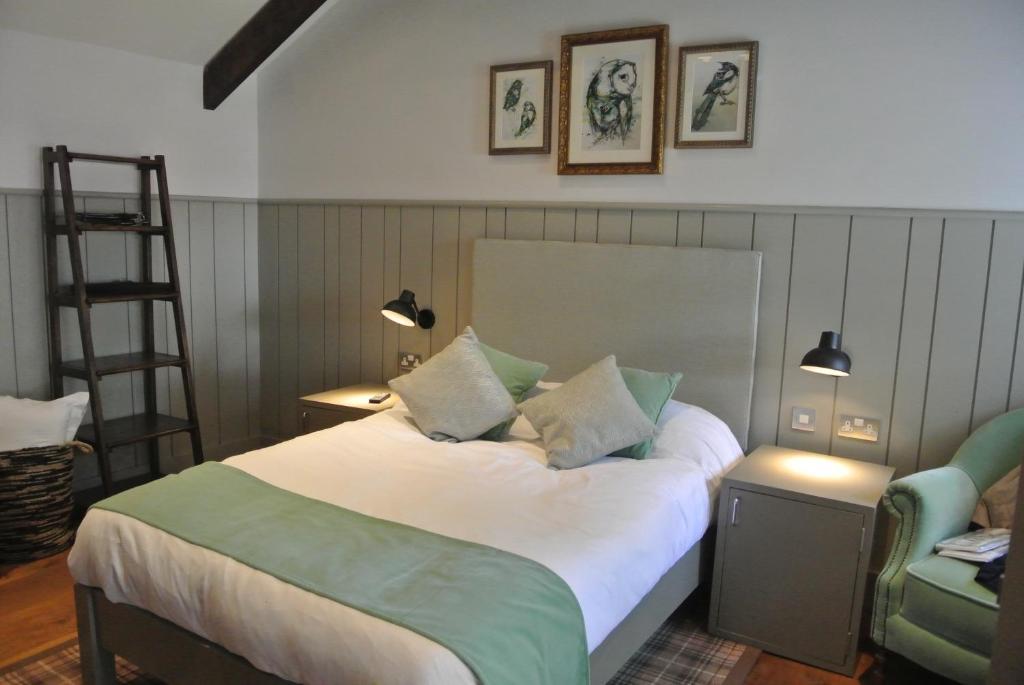 1 dormitorio con 1 cama con escalera y silla en The Crown Pub, Dining & Rooms, en Henlow
