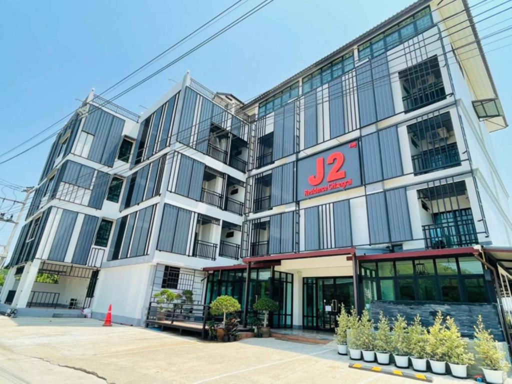 a large building with a sign on it at J2 Residence Chiang Rai in Chiang Rai