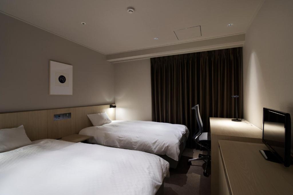 Postel nebo postele na pokoji v ubytování Rhino Hotel Kyoto