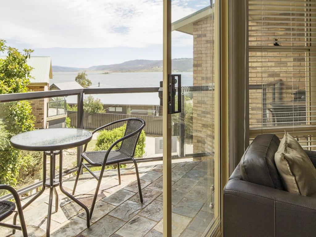 een patio met een tafel en stoelen op een balkon bij Caribou 3 Views over Lake Jindabyne with Wifi in Jindabyne