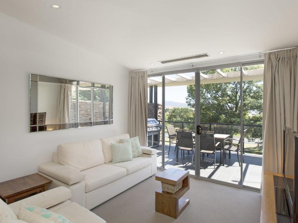 a living room with a white couch and a table at The Edge Apartment 5 Jindabyne in Jindabyne