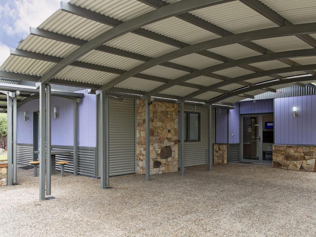 awning over a building with purple walls at Kickenback Studio Contemporary accommodation in the heart of Crackenback in Crackenback