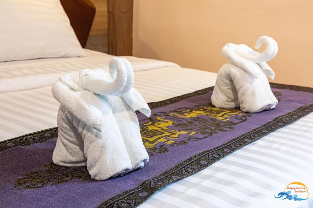 A bed or beds in a room at Naiyang Discovery Beach Resort SHA