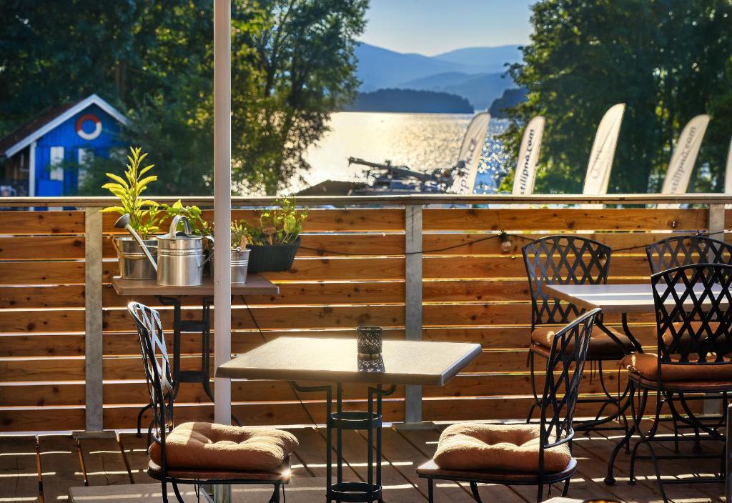 a patio with tables and chairs and a view of the water at Apartmány Panelka Costa Plana Lipno in Černá v Pošumaví