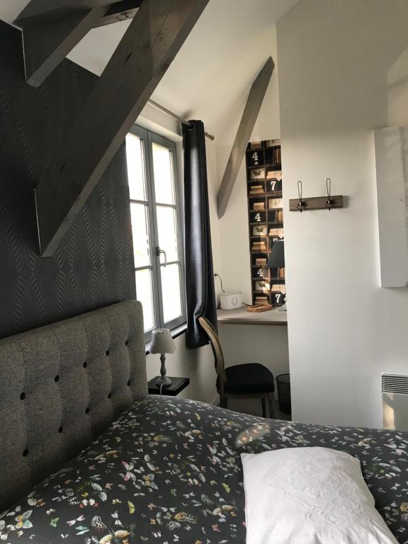 1 dormitorio con cama y ventana en O Mylle Douceurs, en Le Crotoy