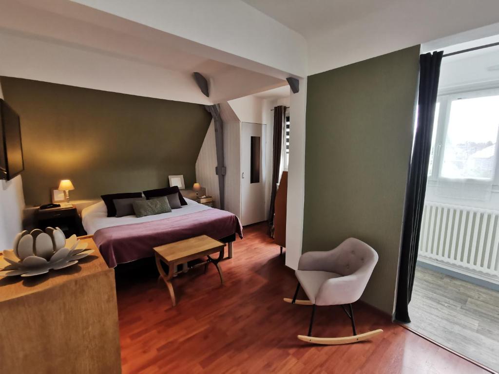 um quarto de hotel com uma cama e uma cadeira em Hotel Restaurant Le Bosquet em Les Ponts-de-Cé