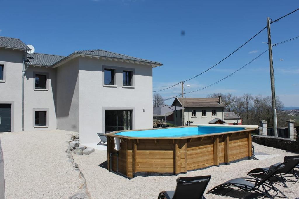 een zwembad in een tuin naast een huis bij L'AYMERAUDE in Messinhac
