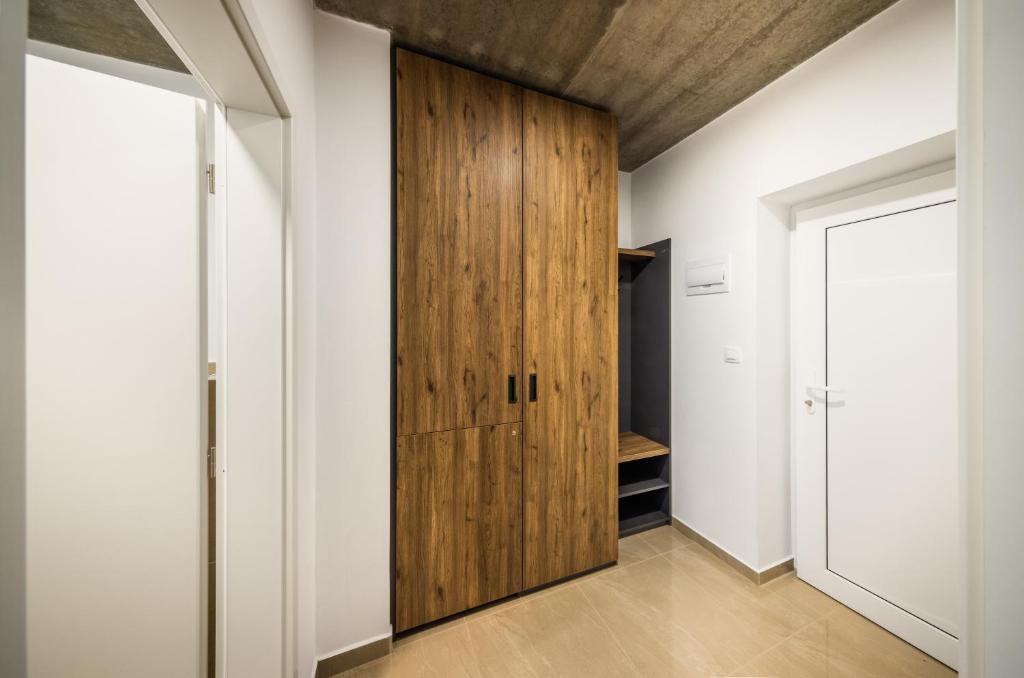 a hallway with a wooden door in a house at Apartmány Panelka Costa Plana Lipno in Černá v Pošumaví