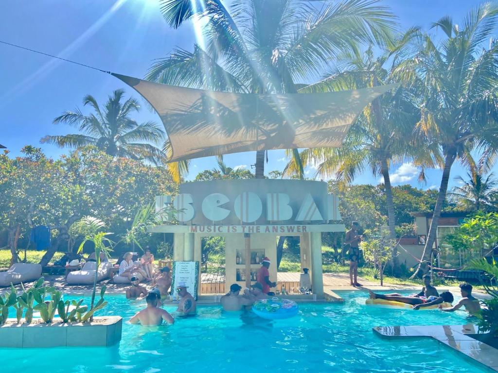 um grupo de pessoas na piscina de um hotel em Mozambeat Motel em Praia do Tofo