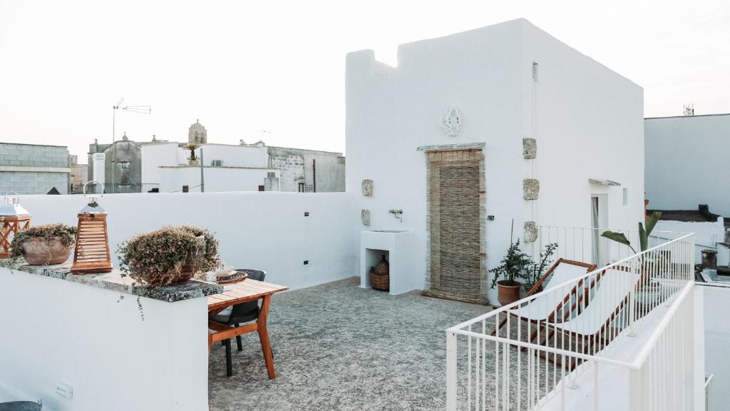 a balcony with white walls and a wooden table at CORTE LARGO LAURO DIMORE & SPA in Gemini