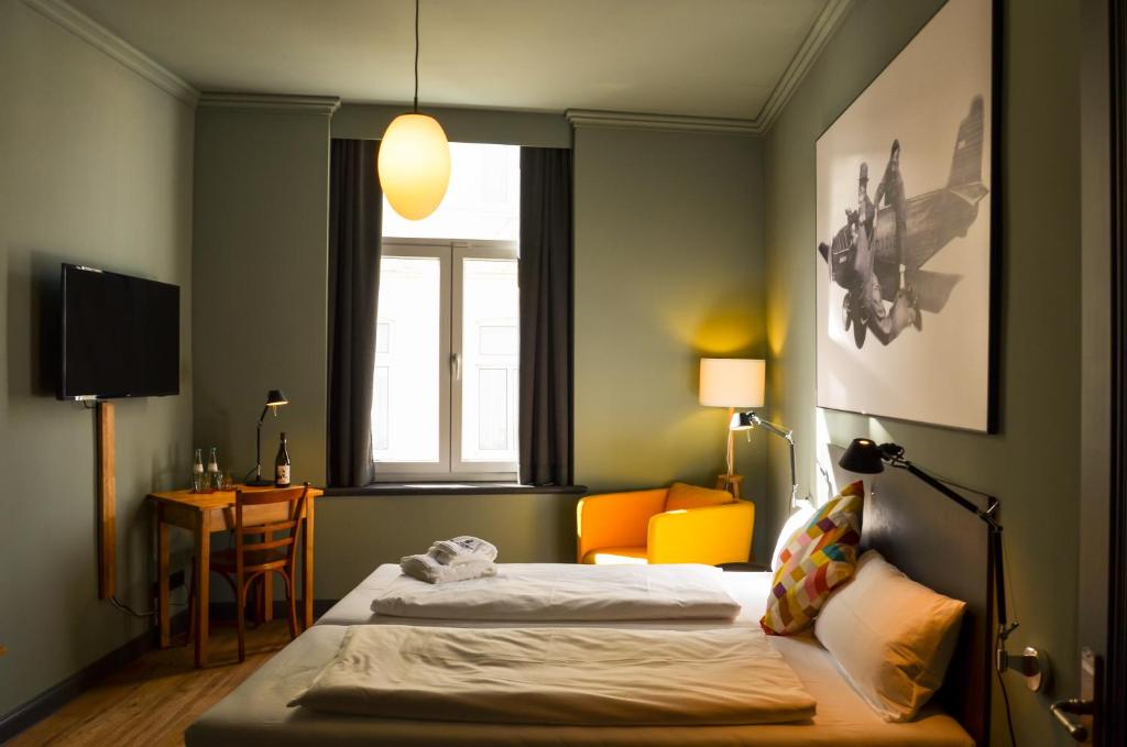 um quarto de hotel com duas camas e uma janela em Storyhotel Bergischer Hof Königswinter em Königswinter