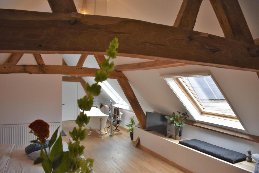 a living room with wooden beams and skylights at De Oude Limonadefabriek in Beek