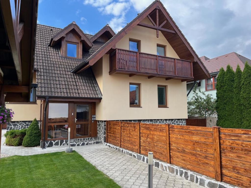 a house with a wooden fence in front of it at Vila Tatra in Stará Lesná