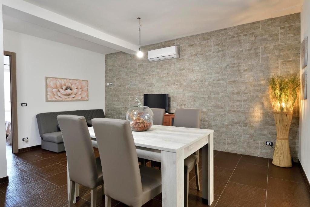 une salle à manger avec une table et des chaises blanches dans l'établissement Damaria, à Loceri