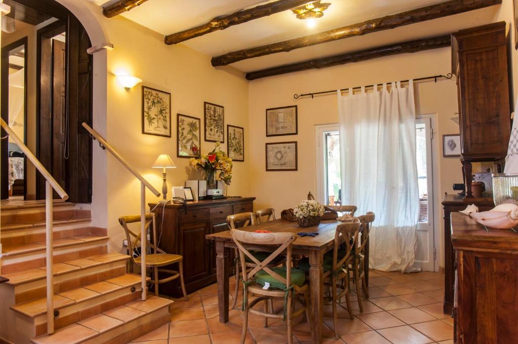 una sala da pranzo con tavolo, sedie e scale di Villa Stella a Santa Margherita di Pula