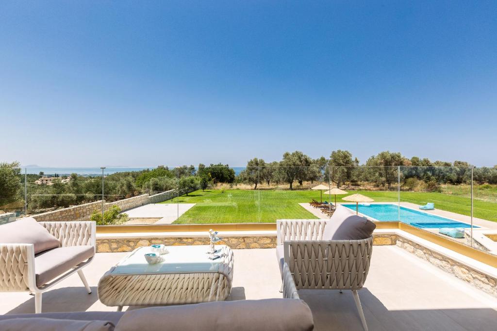 a patio with chairs and a table and a swimming pool at Villa Litinas in Kiriánna