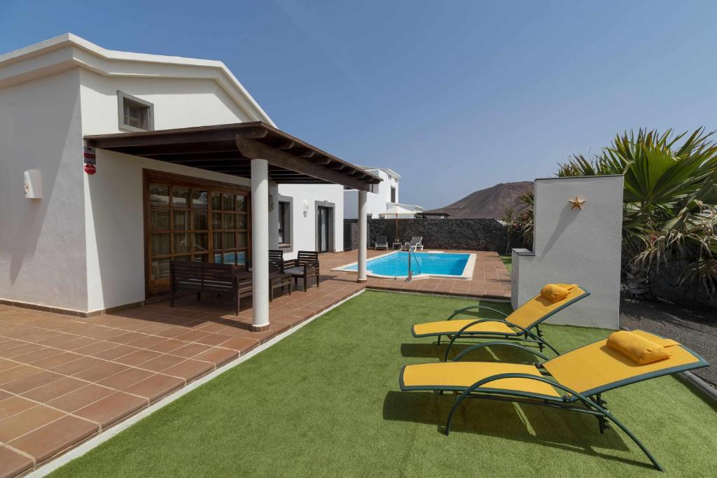 a patio with chairs and a swimming pool at Morning Star in Playa Blanca