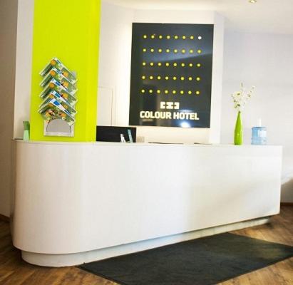 a white counter in a room with a sign at Colour Hotel in Frankfurt/Main