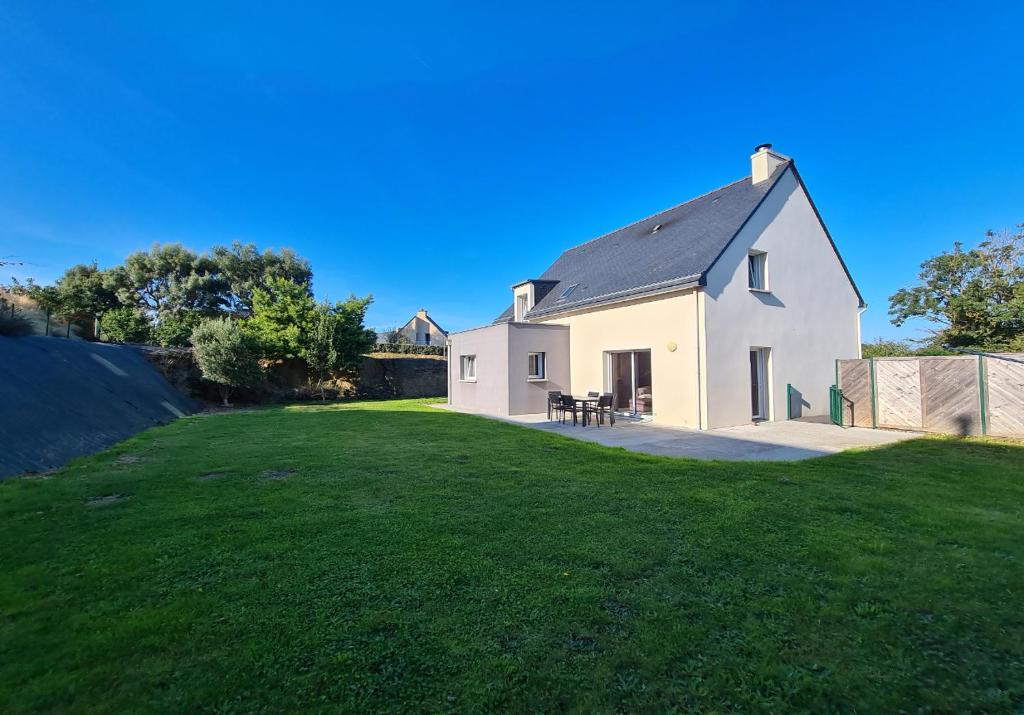 une maison blanche avec une grande pelouse dans l'établissement L'Exploratrice, à Saint-Lunaire
