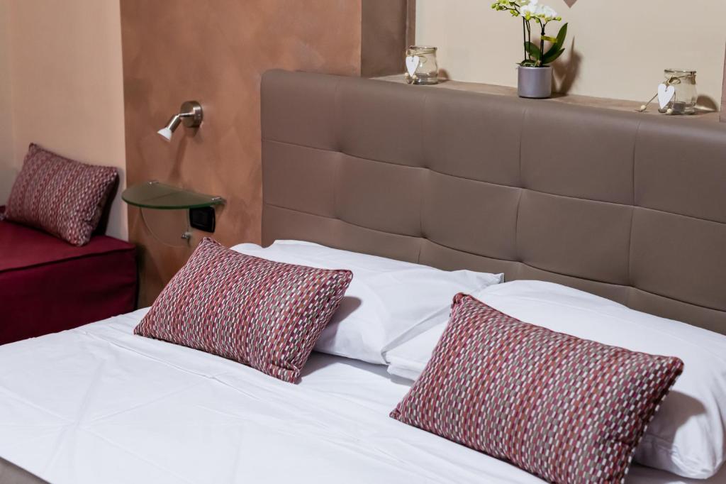 a bed with two red and white pillows on it at Royal Poerio in Naples