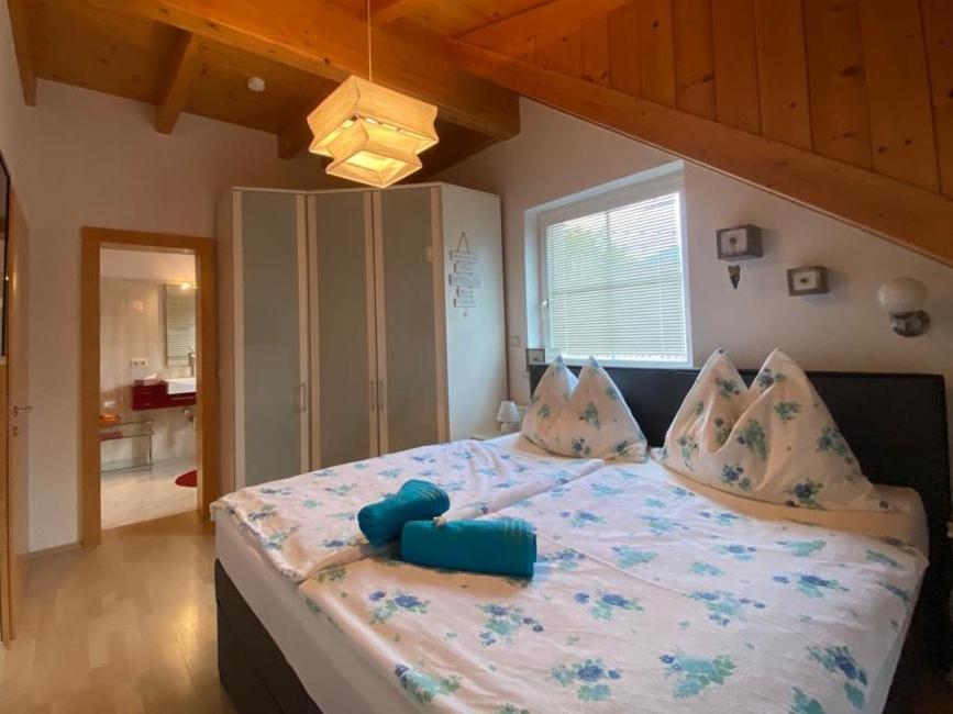 1 dormitorio con 1 cama grande con almohadas azules en Gasthaus zum Fuchs - Familie Andrä, en Hermagor