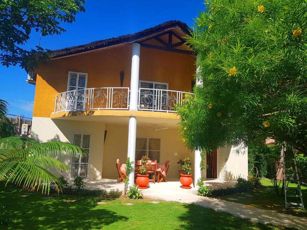 a house with a balcony and a garden at Villa Type Africaine in Saly Portudal