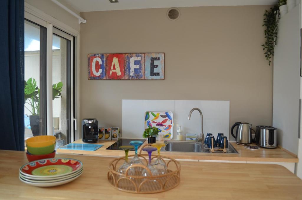- une cuisine avec un comptoir, un évier et une table dans l'établissement Charmant appartement à 350m de la plage et du port, à Fréjus