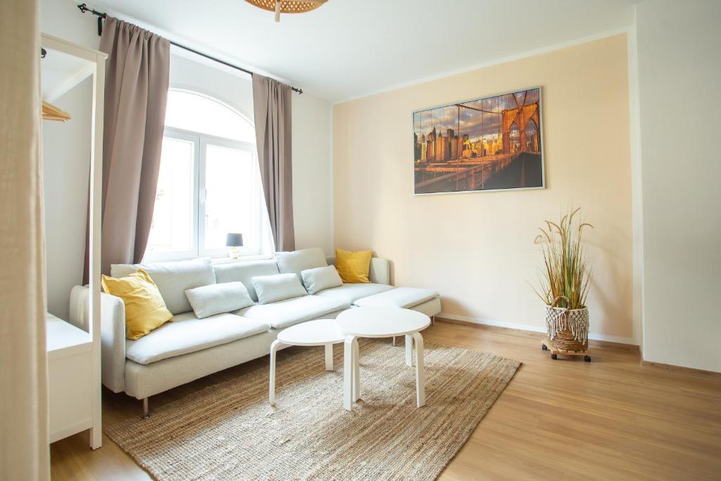 uma sala de estar com um sofá e uma mesa em FULL HOUSE Premium Apartments - Halle Südstadt em Halle an der Saale