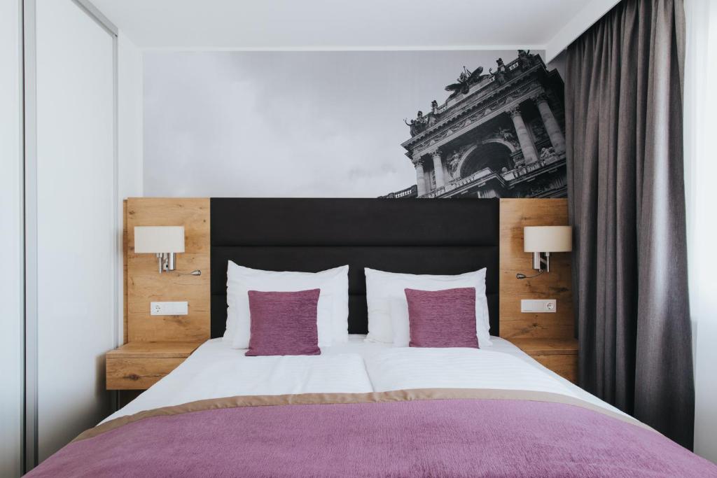 ein Schlafzimmer mit einem großen Bett mit lila und weißen Kissen in der Unterkunft Parks 73 The Townhouse Hotel in Wien