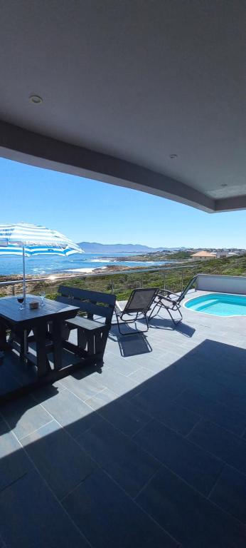a patio with a table and chairs and a swimming pool at Royal Albatros in Gansbaai