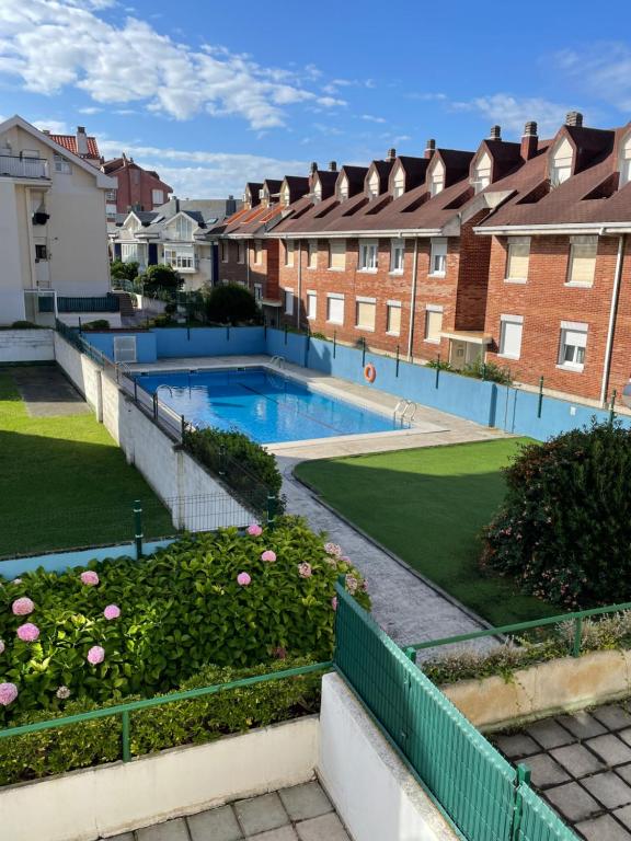 a swimming pool in a yard with houses at Apartamento con piscina y WIFI a 100 metros de la playa en Somo in Somo
