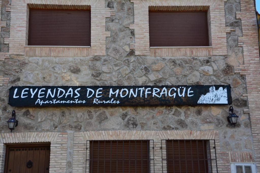 ein Schild an der Seite eines Steingebäudes in der Unterkunft Leyendas de Monfragüe in Torrejón el Rubio