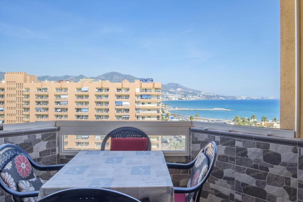 een tafel en stoelen op een balkon met uitzicht op de oceaan bij Stunning Marina view apartment in Fuengirola