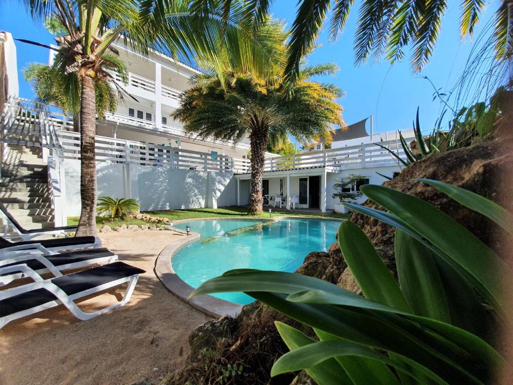 un hotel con piscina y palmeras en B2 APARTMENT with Balcony at JAN THIEL Curacao en Jan Thiel