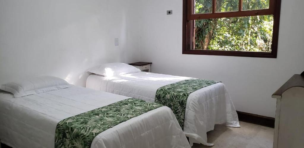 Ένα ή περισσότερα κρεβάτια σε δωμάτιο στο Guaruja, Private Beach Sao Pedro condomínio Sitio São Pedro