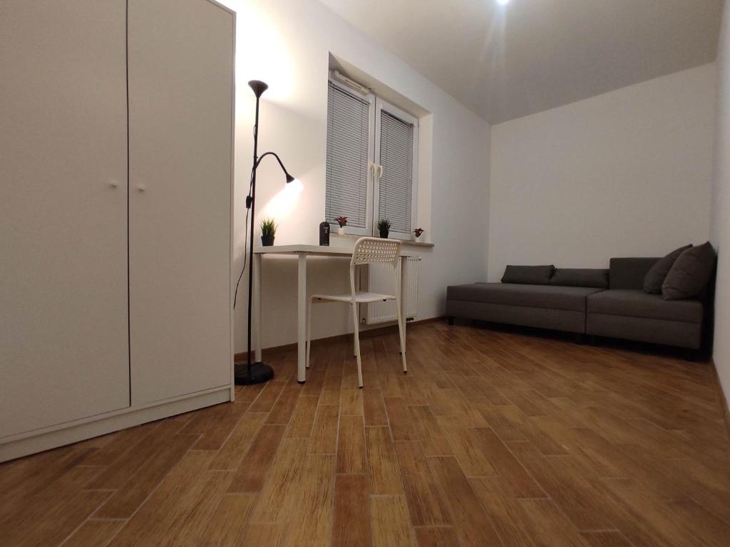 a living room with a table and a couch at Nice room with 2 shared bathrooms ,WC , 2km to old town -100m from Metro Szwedzka in Warsaw